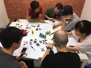 Students playing a Thai card game at a table